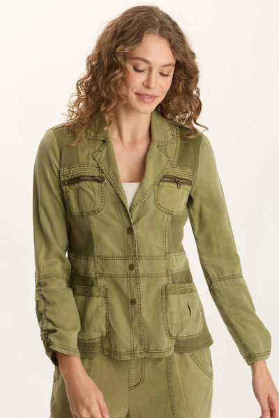 Woman wearing an olive green utility jacket on a white background