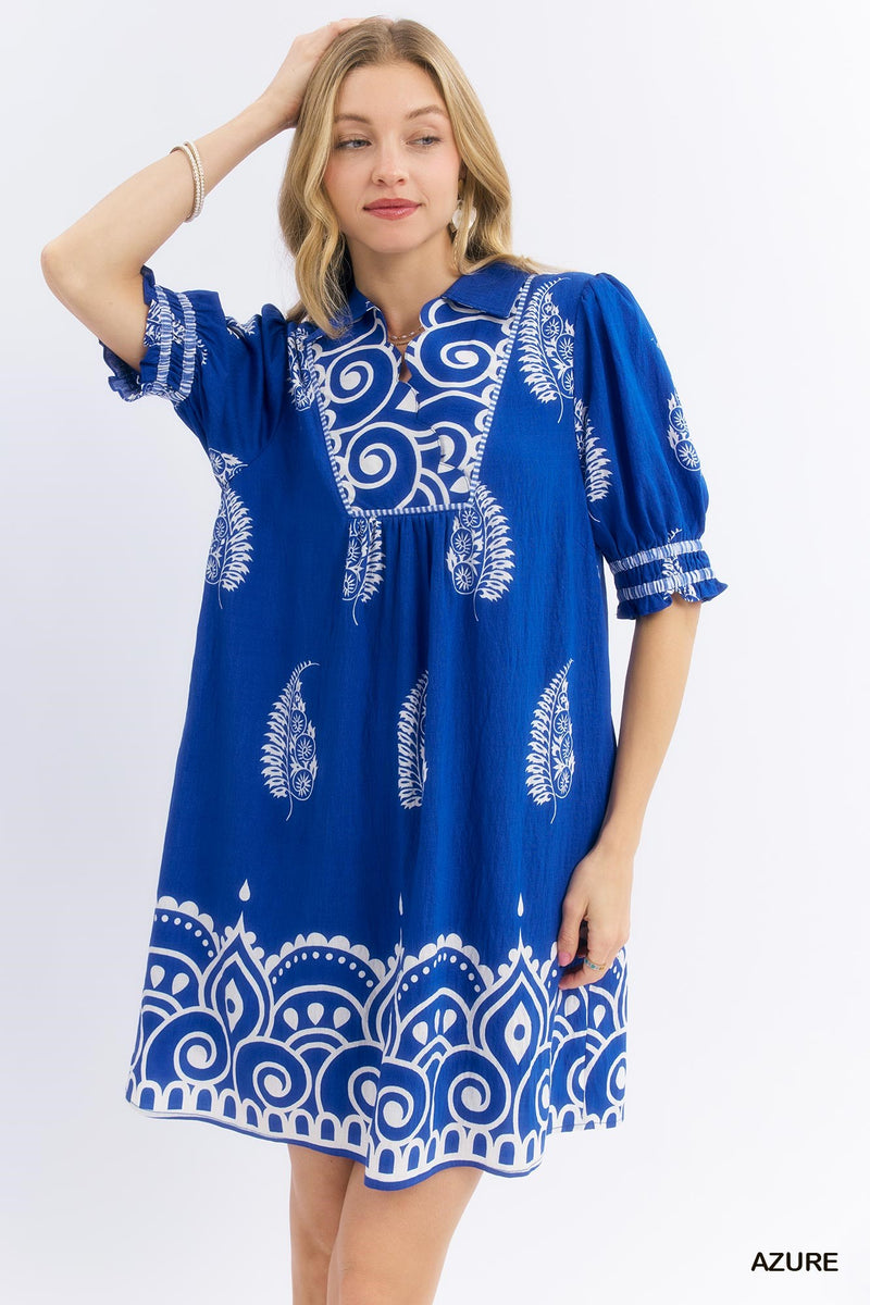 Woman wearing a blue dress with white patterns on a white background