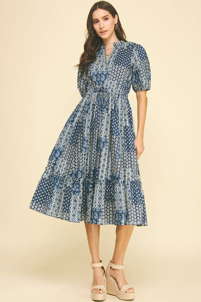 Woman wearing a blue patterned dress on a beige background