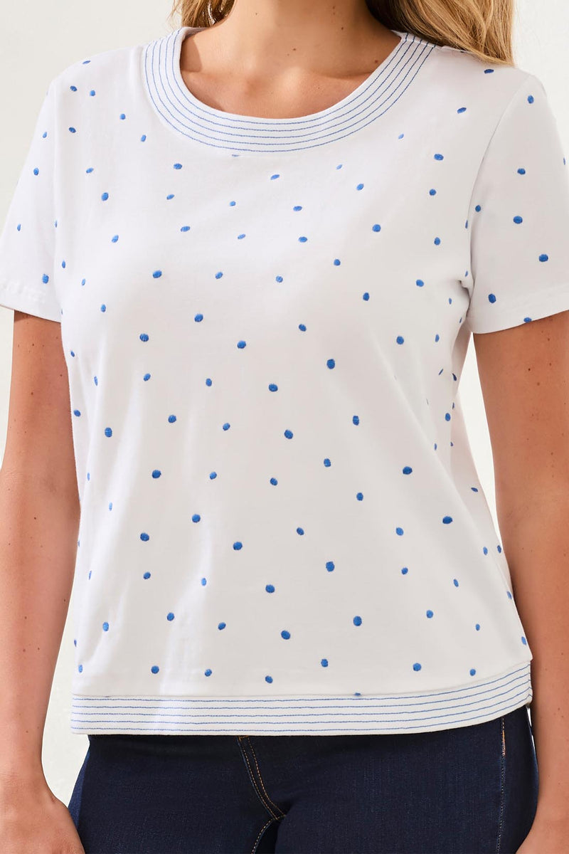 White t-shirt with blue polka dots worn by a person